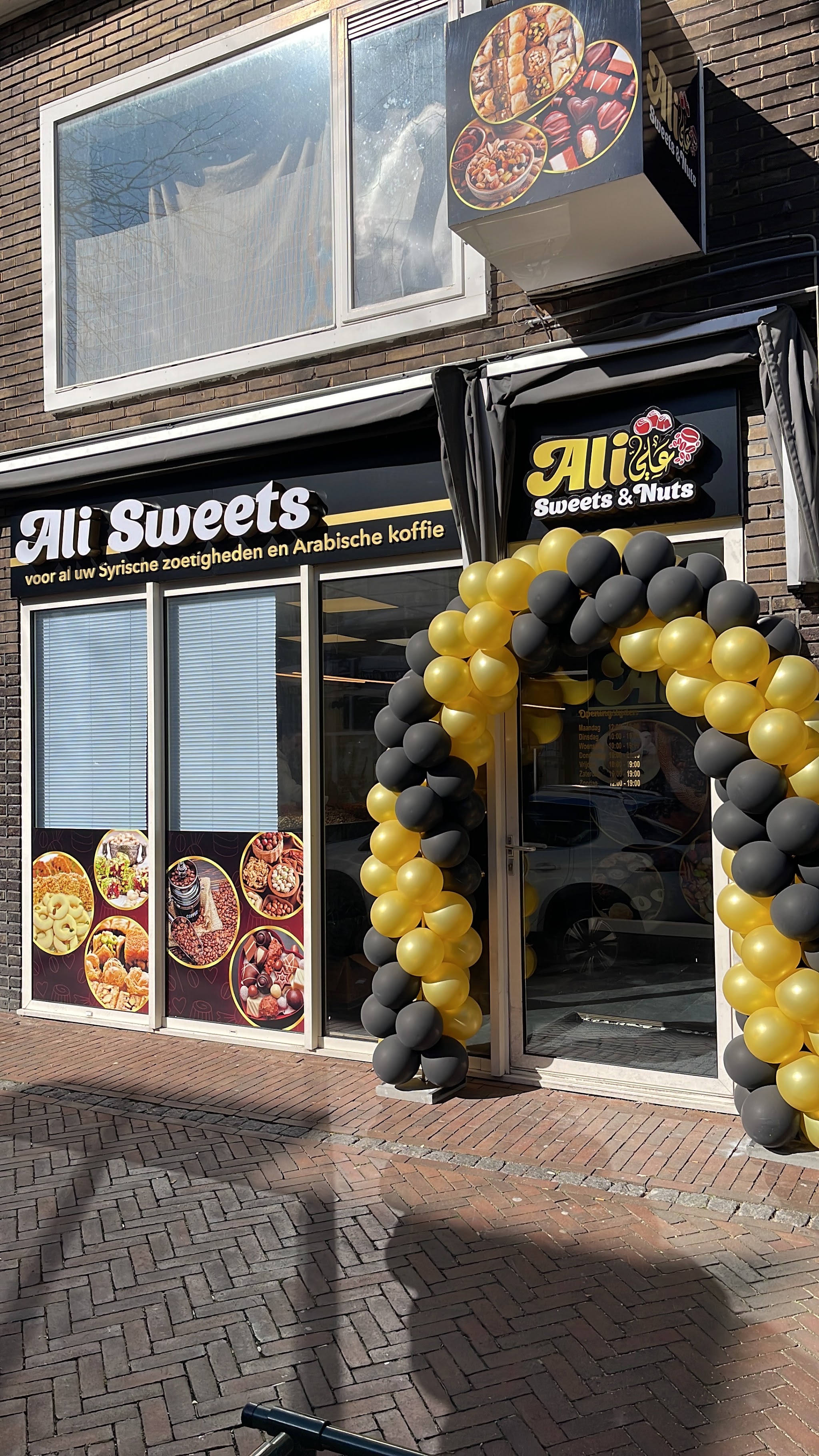 Volledige gevel van Ali Sweets & Nuts, met uithangbord en pui